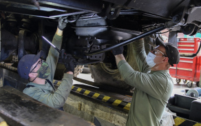 Mechanici kontrolují podvozek a motorovou část nákladního automobilu Tatra.